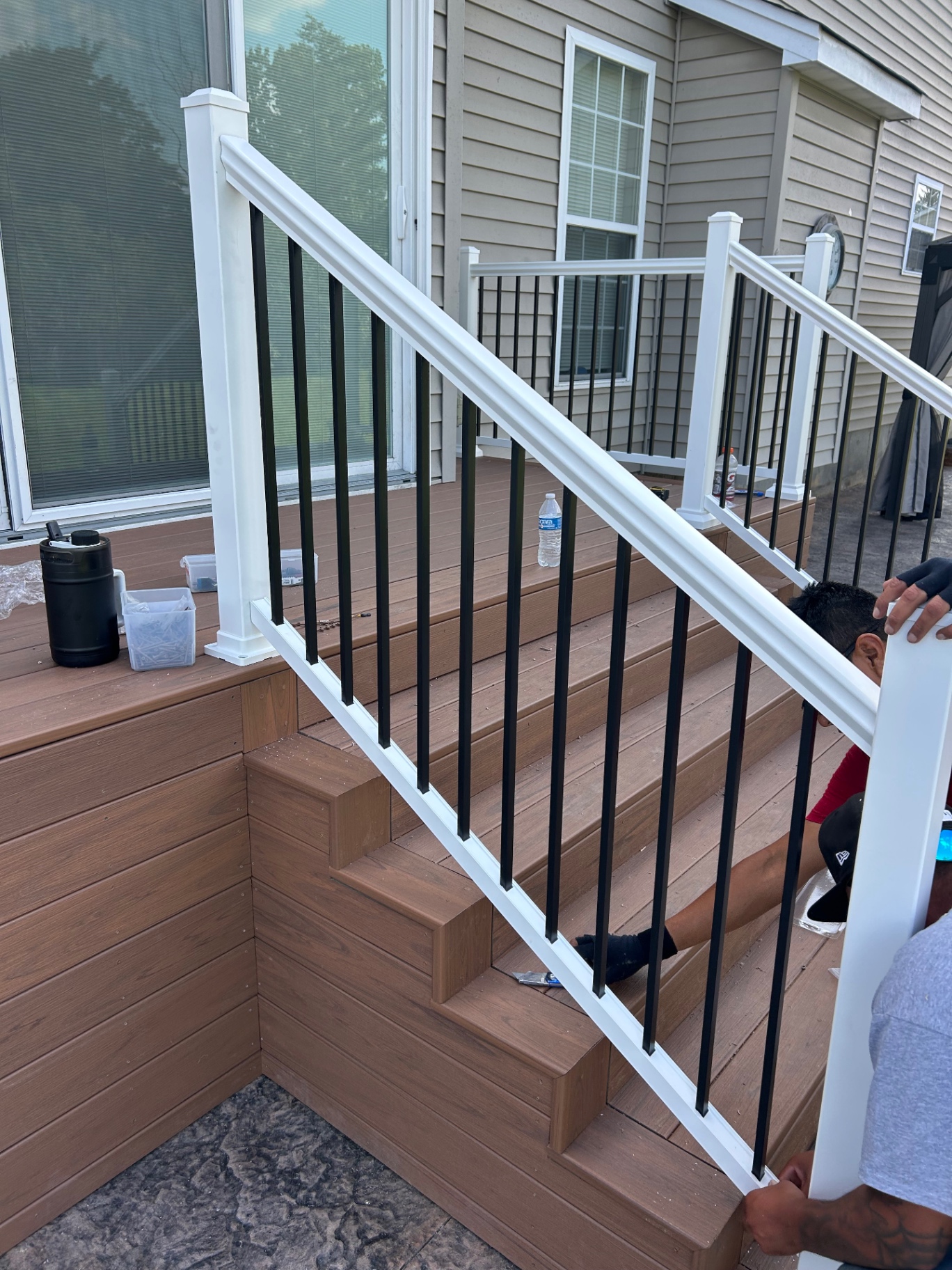 Installing a white vinyl stair railing with black aluminum balusters on a composite deck